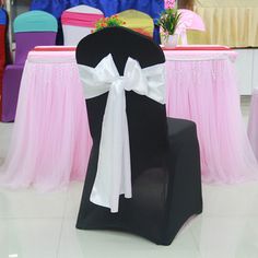 a chair with a white bow on it in front of some other chairs and tables