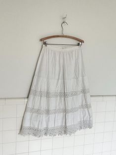 an early 1900s petticoat made from white cotton and hand crocheted panels and trim. double layered.  features a pin in back closure. in  good vintage condition with no rips or  tears. some spots on back. see last pictures for closeup.  please note waist measurement are flexible because of cinched waist  waist:28' length 31' Vintage Lace Petticoat For Summer, Vintage Lace Trim Petticoat For Summer, White Tiered Gathered Petticoat, White Lace Trim Tiered Petticoat, Vintage Cotton Petticoat For Daywear, White Cotton Petticoat With Lace Trim, White Cotton Skirt-shape Petticoat, Vintage Cotton Tiered Petticoat, Vintage Cotton Petticoat With Gathered Skirt