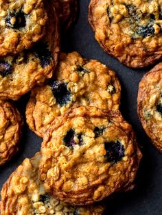 several blueberry oatmeal cookies are on a black surface with one cookie in the middle