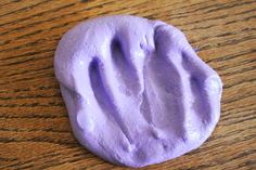 a close up of a purple substance on a wooden surface