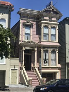 a car parked in front of a pink house