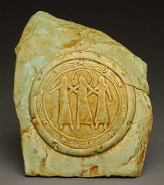 a stone with an image of two people and a circle in the middle on it