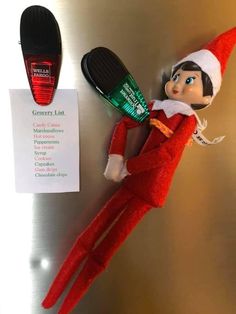 an elf is laying on the refrigerator next to a toothbrush