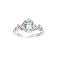 a white gold ring with an oval aqua blue topazte and diamonds on the band