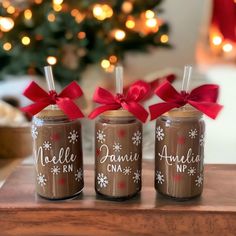 three brown jars with red bows are sitting on a table