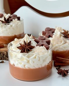 two desserts in small glass dishes on a white table with cinnamon and star anise