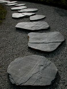 stepping stones are arranged in a line on the gravel