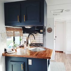 a kitchen with wooden counter tops and blue cabinets