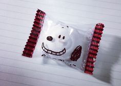 a candy bar wrapped in red and white paper with a smiling face on it's wrapper