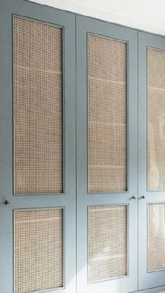 an empty room with blue doors and wicker panels