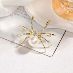 Unleash your daring side with this Alloy Pearl Diamond Spider Brooch! This striking accessory combines the elegance of pearls and the sparkle of diamonds with the boldness of a spider design. Show off your unique and fearless style with this brooch, perfect for any fierce fashionista! Tarnish proof Water proof Sleep / Nap proof Safe for sensitive skin Wear it while working out &showering Designed to wear 24/7 If there is no stock, the product will take 60 days to produce Please leave your usual email address and phone number for order contact There is a discount code on the store homepage, limited to one time per person, welcome to use Details Materials: Alloy Stone: CZ Diamond Weight: 9G SKU：AN24071207 Spider Brooch, Sun And Moon Rings, Spider Design, Moss Agate Ring, Flat Back Earrings, Toggle Bracelet, Gold Brooches, Feather Necklaces, Pearl Brooch