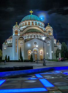 a church lit up at night with blue lights