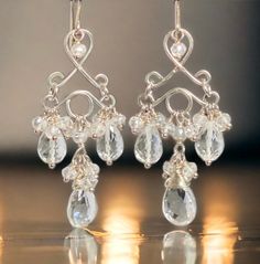 Sterling silver, handmade chandelier earring forms dangle faceted crystal quartz teardrops and pear shape gemstones to create these very feminine earrings; The gem stones have a beautiful faceting that just shimmers beautifully in the light while the smaller, mystic crystal quartz rondelle beads sparkle on the sides.   These handmade earrings are an easy to wear size, lightweight,  and they are definitely eye-catching. Great bridal earrings! Total length of earrings, including ear wires, is 2 3/8 inches.   Much much prettier in person! Please choose your desired earring style from the drop down menu.  If you are interested in pave style earrings, please inquire for availability when you are ready to purchase. To enter my shop: https://www.etsy.com/shop/DoolittleJewelry?ref=si_shop Copyrigh Silver Gemstone Dangle Bridal Earrings, Elegant Long Drop Crystal Earrings With Dangling Beads, Silver Crystal Chandelier Earrings With Dangling Beads, Sterling Silver Dangle Crystal Earrings With Pearl Drop, Elegant Silver Teardrop Earrings With Dangling Beads, Elegant Sterling Silver Chandelier Earrings With Gemstones, Elegant Faceted Chandelier Earrings, Elegant Briolette Gemstone Chandelier Earrings, Wedding Gemstone Drop Chandelier Earrings