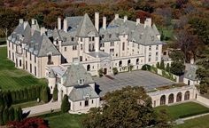 an aerial view of a large mansion in the middle of trees and grass, surrounded by fall foliage