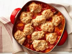 a casserole dish filled with meatballs and sauce on top of a white table