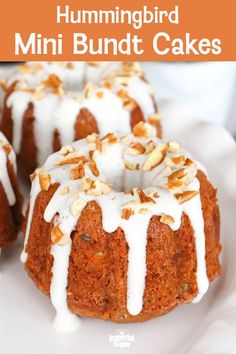 a bundt cake with white icing and nuts on top sitting on a plate