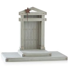 a small white wooden shrine with a star on it's top and the door open