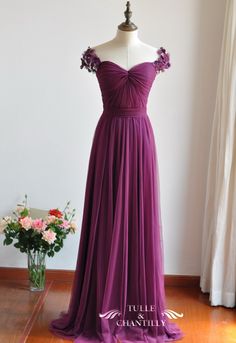 a purple dress on a mannequin in front of a white wall and window