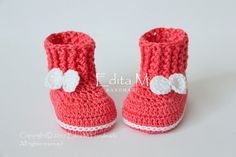 a pair of crocheted baby shoes with bows