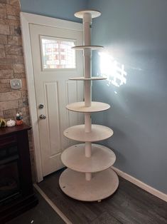 a three tiered shelf in the corner of a room with a door and window