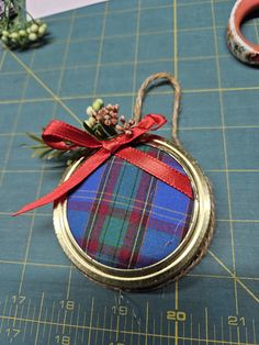 an ornament with a ribbon tied around it on top of a cutting board