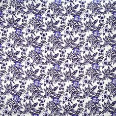 a blue and white flowered fabric with small purple flowers on the bottom half of it