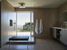 a bathroom with a bench, shower and large window