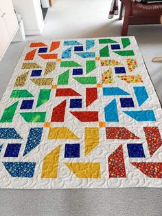 a colorful quilt on the floor in a room