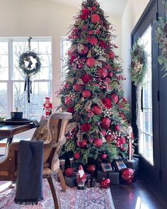 a christmas tree decorated with red flowers and greenery