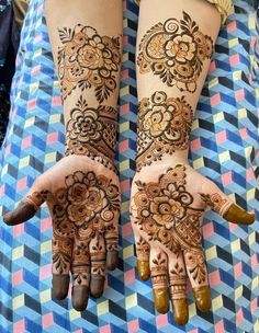 two hands with henna designs on them