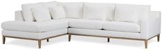 a white sectional couch with pillows on it's back and side ends, viewed from the front