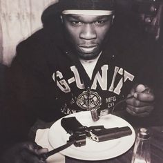 a man sitting at a table holding a plate with some chocolates on top of it