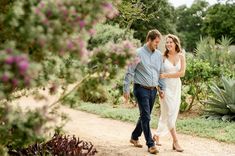 a man and woman walking down a dirt road