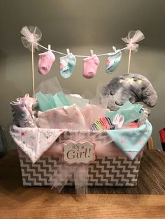 a baby girl gift basket with socks, diapers and an elephant on a clothes line