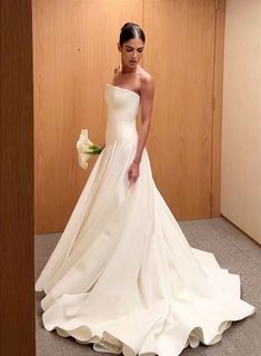 a woman in a white wedding dress posing for the camera