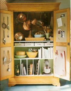 an open cabinet filled with pots and pans