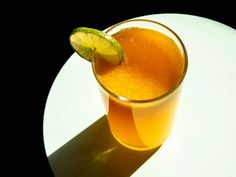 an orange drink with a lime slice on the rim