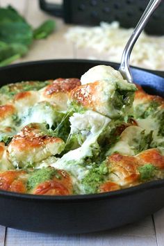 broccoli and cheese casserole in a skillet with a serving spoon