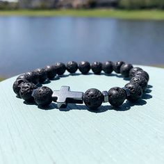 Step into a realm of serenity and spirituality with our 8mm Black Volcanic Rock Christian Beaded Bracelet. Crafted from the earth's raw energy, each volcanic rock bead embodies strength and resilience, providing a grounding foundation for your spiritual journey. At its core, a silver cross symbolizes the timeless grace and guidance found in Christian faith. As you wear this bracelet, allow its presence to anchor your intentions and connect you with the healing power of divine love. With complime Spiritual Lava Stone Stretch Bracelet Gift, Casual Rosary Bracelet With 8mm Beads As Gift, Spiritual Lava Stone Bracelets With 8mm Beads, Spiritual Lava Stone Beaded Bracelets With 8mm Beads, Spiritual Adjustable Cross Beaded Bracelets, Spiritual Rosary Bracelet With Natural Stones For Meditation, Adjustable Spiritual Cross Beaded Bracelets, Black Cross Bracelet As Gift, Casual Cross Jewelry Gift