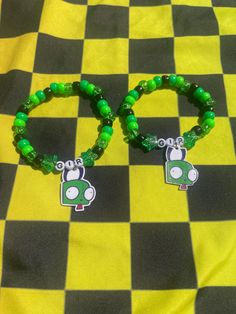 Kandi bracelet of Gir that I made :0 Two sizes to choose from M - 19 CM L - 21 CM The bracelet itself is stretchy and durable. Charms are drawn by me and sealed, I hand make these so keep in mind they aren't perfect. Green Themed Beaded Bracelets As Gifts, Themed Green Beaded Bracelets As Gift, Green Themed Beaded Bracelets, Themed Green Beaded Bracelets For Gifts, Handmade Green Novelty Beaded Bracelets, Handmade Green Beaded Novelty Bracelet, Handmade Green Novelty Beaded Bracelet, Casual Plastic Wristband Gift, Green Novelty Bracelets With Round Beads