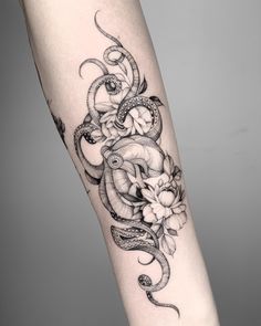 a woman's leg with an octopus and flowers tattoo on the side of her arm