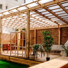 an outdoor living area with wooden pergols and green grass in the foreground