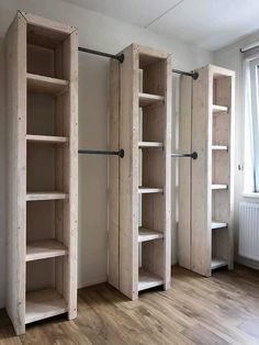 an empty room with three wooden shelves in it