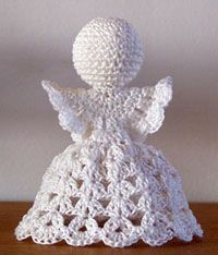 a white crocheted angel sitting on top of a wooden table