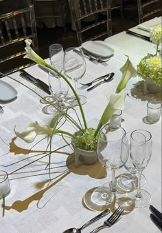 the table is set with silverware and flowers