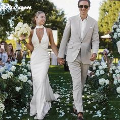 a bride and groom walking down the aisle at their outdoor wedding ceremony with white flowers