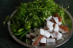 a plate filled with chopped up vegetables on top of a green tablecloth covered counter