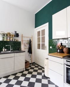 a kitchen with black and white checkered flooring next to a stove top oven