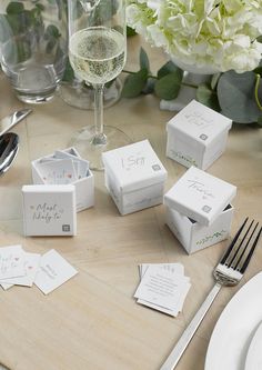 the table is set with place cards, silverware and wine glasses for guests to enjoy