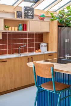 a kitchen with blue chairs and wooden cabinets